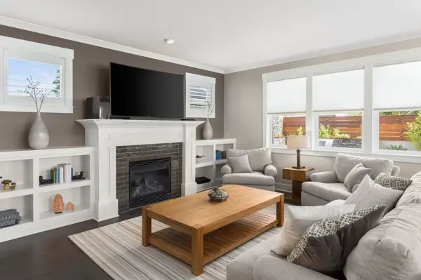 Living room with built-in shelving and a tiled fireplace