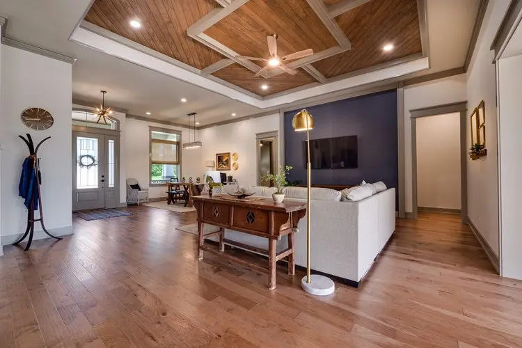 Open living room with coffered wood ceiling and hardwood floors