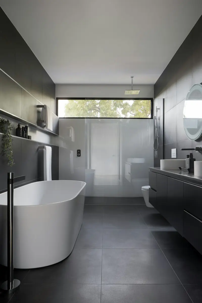 Modern bathroom with a soaking tub and dark tile
