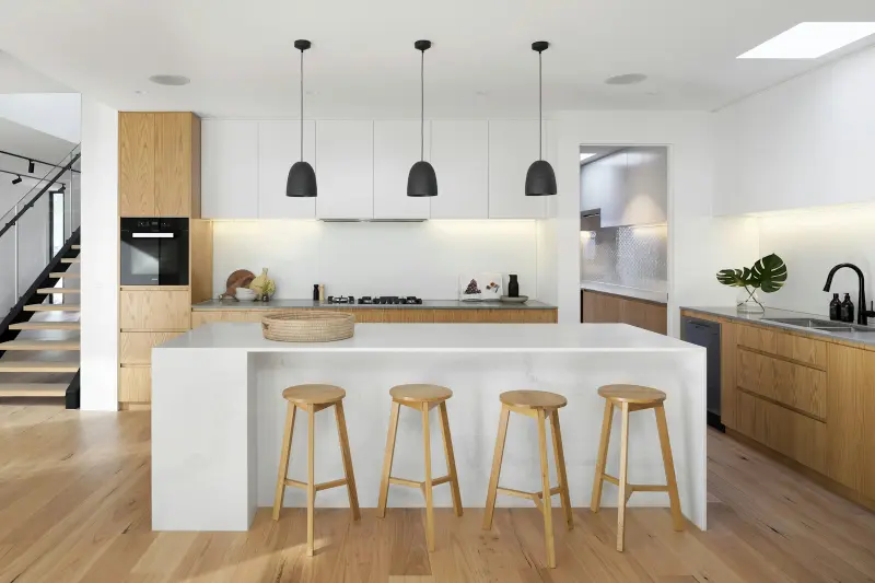 Modern kitchen with a waterfall island and wood stools