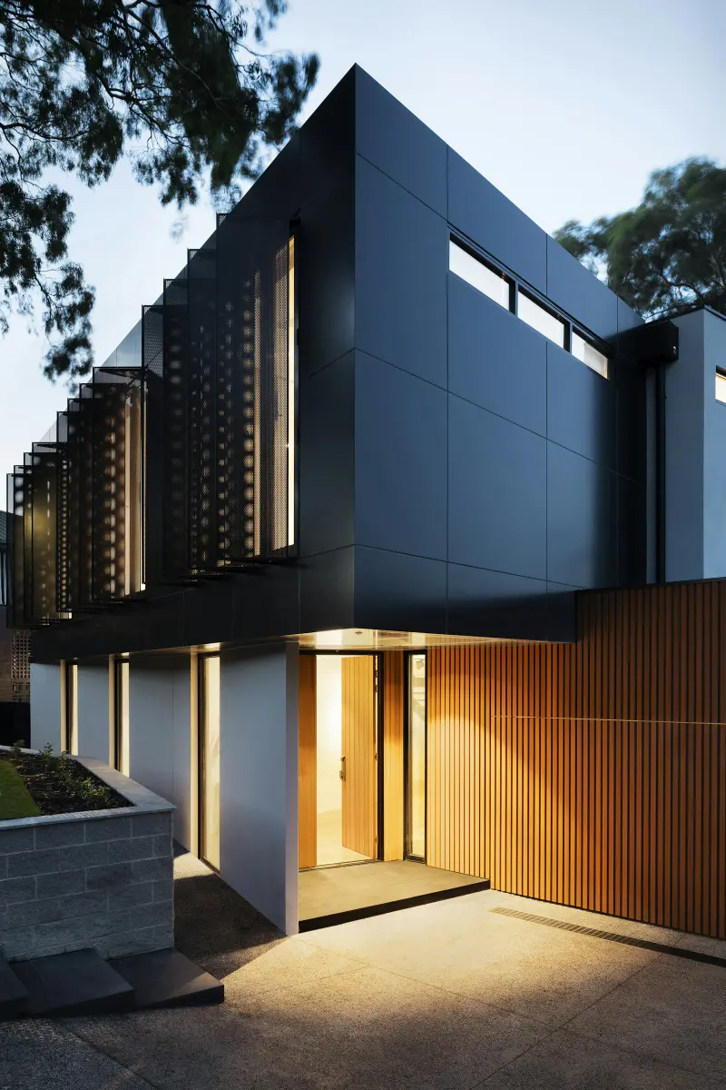 Modern home exterior with wood cladding at night