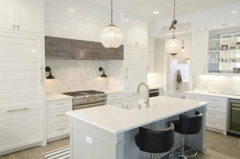 White kitchen with crystal pendants and a large island